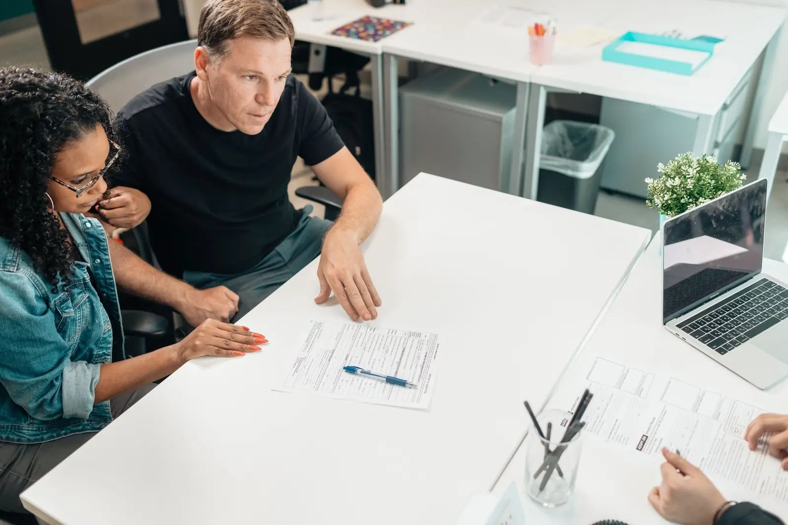 Couple at a desk looking over a form with a pen
