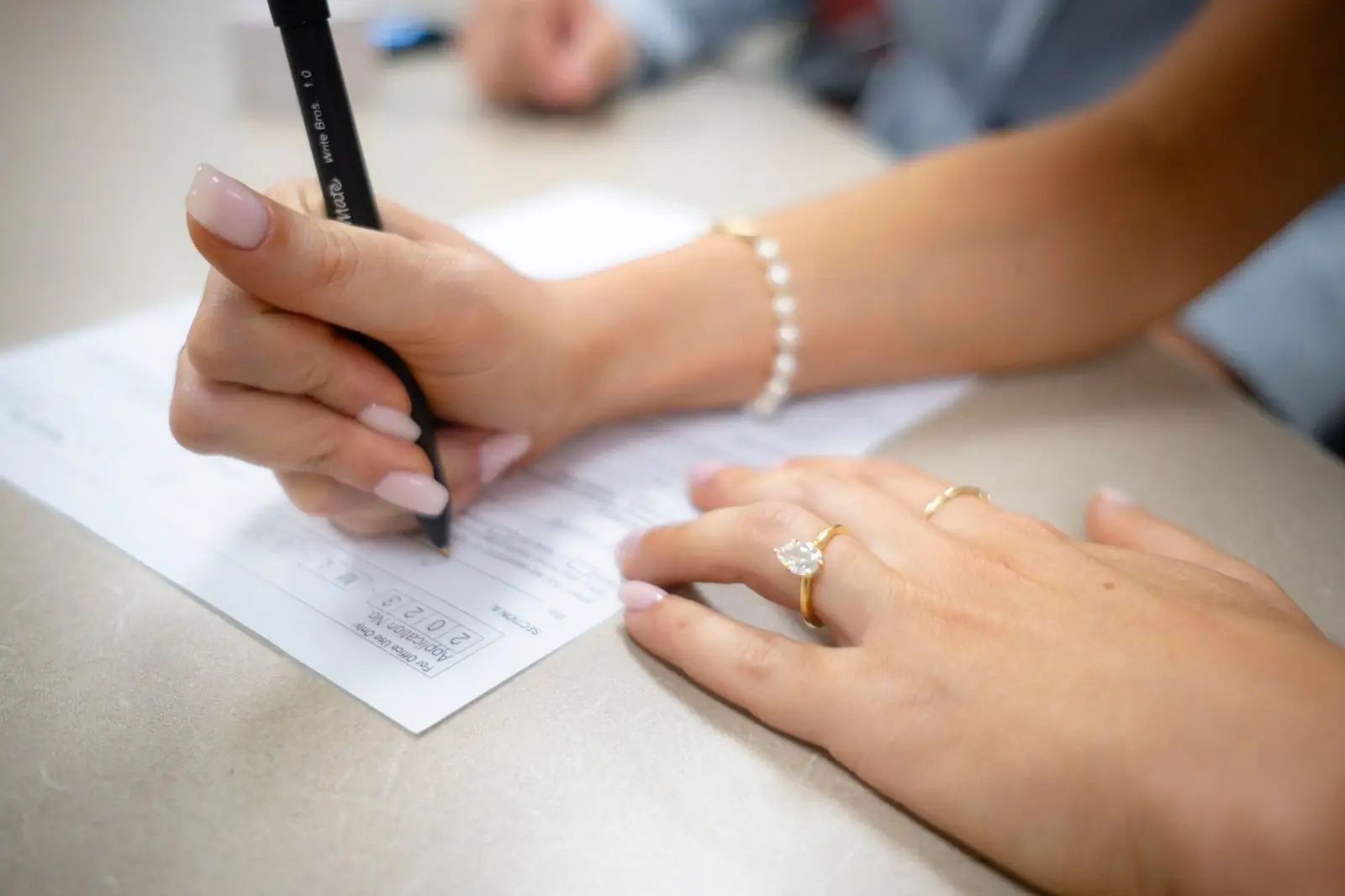 A person signing a printed document at a desk