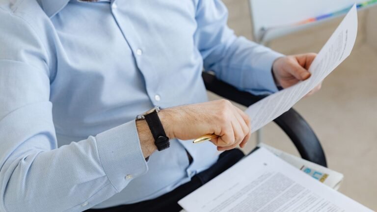Man in a blue shirt reading a document to see if Dubai court is open on Saturday